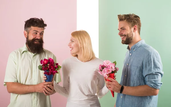 Girl popular receive lot men attention. Woman smiling can not choose partner, grabs both bouquets. Men competitors with bouquets flowers try conquer girl. Girl happy likes gifts. Love triangle — Stock Photo, Image