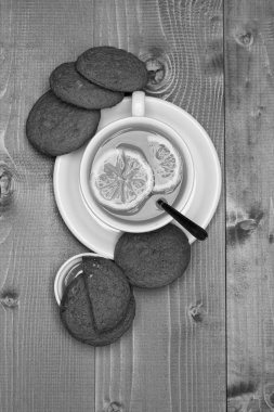 Gri ahşap arka planda çayın yanındaki kurabiyeler.