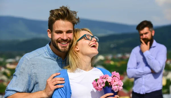 Os amantes abraços ao ar livre flertar relações românticas. Casal romântico namorados flores bouquet. Conceito de infidelidade. Casal apaixonado namoro enquanto homem barbudo ciumento assistindo esposa traindo-o com amante — Fotografia de Stock