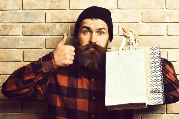 Bärtiger brutaler kaukasischer Hipster mit Schnurrbart hält Einkaufspakete in der Hand — Stockfoto