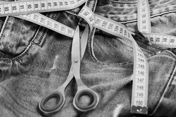 Jeans belt loops, zipper and pocket with scissors, selective focus.