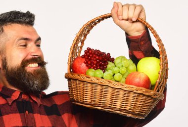 Adam kendi ekinlerini biçiyor. Sakallı adam meyve sepeti tutuyor.