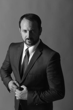 İşadamı akıllı takım elbise ve kravat takıyor. Lider ceket unbuttons