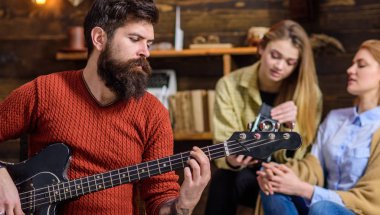 Kesilmiş sakal ve bıyık elektrik gitar tutan adam. Müzisyen içinde pişmiş toprak kazak trendy izlemek ve albüm kapağı için poz büyük yüzük takıyor. Sakallı adam müzik konsantre