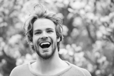 Adam gülümseme çiçek açması ağaçları ile parkta