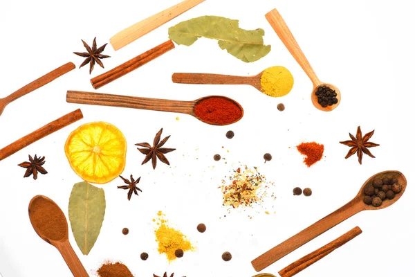 Kaşık mutfak otlar, Yıldız anason ve beyaz zemin üzerine defne yaprağı ile. Kaşık mutfak otlar ve baharatlar ile dolu. Baharat ve kuru malzemeyi kaşıklarla bileşimi. Mutfak sanat kavramı.