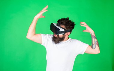 Hippi ilham ifade ile modern aracı Vr keşfetmek ile. VR gadget kavramı. Adam kafa monte ekran ile etkileşim içinde sanal gerçeklik. Vr gözlük, yeşil arka planda sakallı