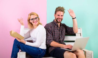 Kız koca freelancer laptop ile çalışırken hayatını tadını çıkarın. Yüz kitap çalışan erkeğin yakınındaki okuma gülümseyen kadın. Adam serbest üzerinde Internet teknolojileri uzmanı çalışıyor. Serbest faydaları