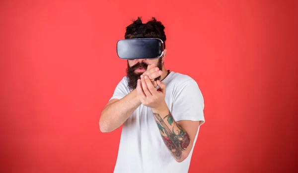 Virtuelle schießgalerie concept.guy mit kopf montiert display schießen mit pistole in virtueller realität. Mann mit Bart und Brille, roter Hintergrund. Hipster auf geschäftigem Gesichtsspiel in Virtual Reality — Stockfoto