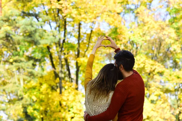 L'uomo e la donna girato all'indietro su alberi di autunno sfondo — Foto Stock