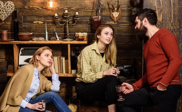 Amigos, familia pasar la noche agradable, fondo interior. Amigos teniendo un gran día en la casa de los guardabosques. Concepto de conversación sincera. Las niñas y el hombre en caras relajadas sostienen tazas metálicas, hablando —  Fotos de Stock