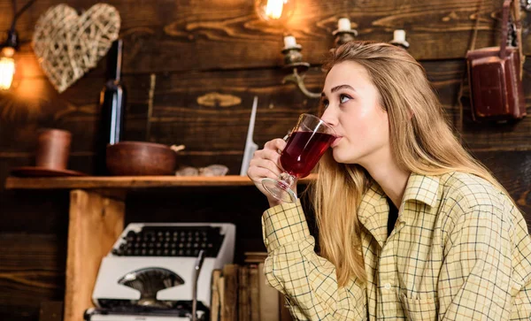 Mädchen in lässigem Outfit sitzt im hölzernen Vintage-Interieur. Mädchen-Tomboy entspannen bei Glas mit Glühwein im Haus des Wildhüters. Dame auf verträumtem Gesicht in karierten Kleidern sieht niedlich und lässig aus. Entspannungskonzept — Stockfoto