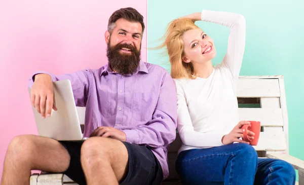 L'uomo lavora come esperto di tecnologie internet freelance. Ragazza godere di bere mentre il marito freelance lavora con il computer portatile. Benefici freelance. Donna sorridente faccia bere tè o caffè vicino all'uomo di lavoro — Foto Stock