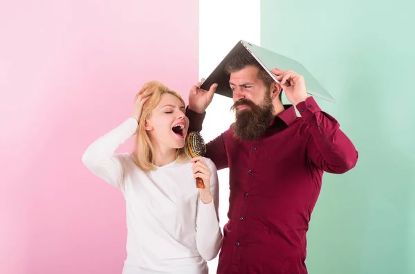 Mejor cantar en el concurso de talentos que en el trabajo. Lady imagina que es una cantante con talento superestrella. Cantar es su pasión. Señora cantar usando cepillo de pelo como micrófono mientras el hombre molesto esconderse debajo de la computadora portátil — Foto de Stock