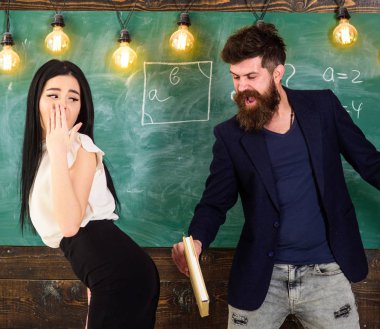 Kız çaresiz yüz öğretmen tarafından cezalandırılır. Adam sakal tokat seksi öğrenci, kara tahta arka plan ile. Öğretmen kitap ile onun kalça üzerinde tokat ile seksi öğrenci cezalandırır. Rol oyun concep
