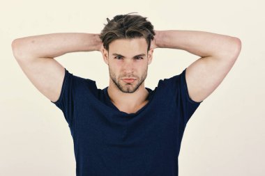Koyu mavi tshirt kıl herif. Ellerini başının arkasında maço emin yüz tutar.