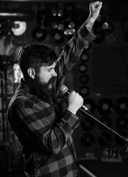 Hipster likes to sing on stage. Man with enthusiastic face holds microphone, singing song, — Stock Photo, Image