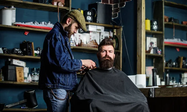 コンセプトをグルーミングします。ひげと流行に敏感なスタイリッシュな理髪店でプロの床屋であり岬を覆われています。流行に敏感なクライアントのひげの手入れで忙しい理髪店、美容用品の背景 — ストック写真