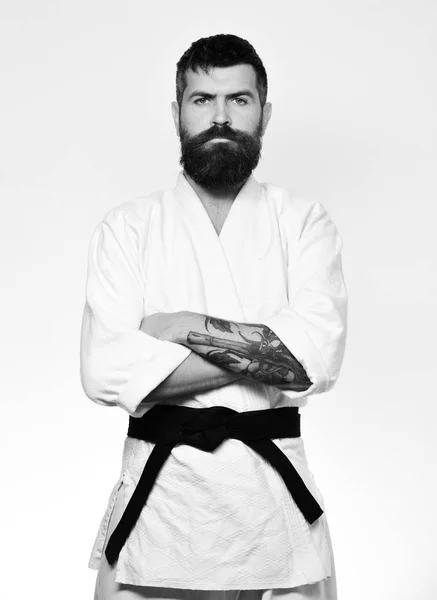 Man with beard in white kimono on white background. Japanese martial arts concept. Taekwondo master with black belt — Stock Photo, Image