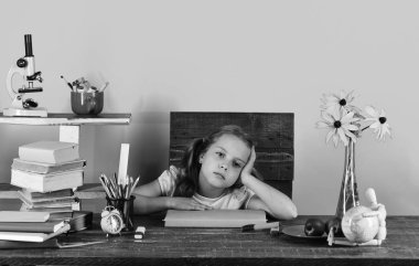 Kız yorgun yüz ifadesi ile. Renkli Kırtasiye, kitap, küre, saat ve çiçekler ile kız öğrenci