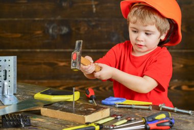 Kavram handcrafting. Yürümeye başlayan çocuk meşgul yüzündeki çekiç aracı evde atölye ile oynuyor. Çocuk Çocuk tamirci oynamak. Çocuk kask Oluşturucu veya repairer, onarımı veya handcrafting olarak oynayan sevimli içinde