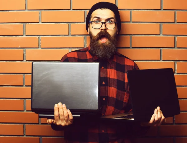 Skäggig brutal kaukasisk hipster som håller bärbara datorer — Stockfoto