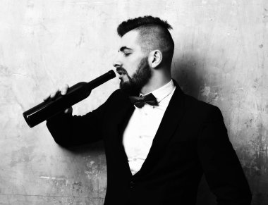 Yorgun yüzlü genç klas adam alkollü içecek içiyor.