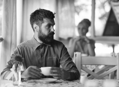 Sakal ve ciddi bir yüz tutan bardak içki olan adam