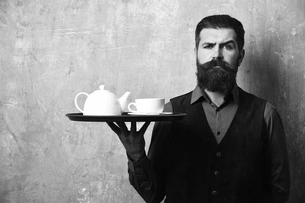 Sakallı ve bıyıklı adam bej rengi duvarda çay tutuyor. — Stok fotoğraf