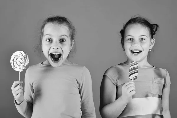 Niños con caras alegres posan con caramelos en verde — Foto de Stock