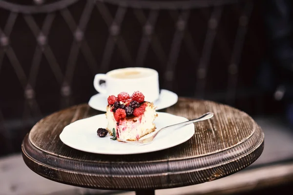 Cheesecake with berries and coffee on wooden table — Stock Photo, Image