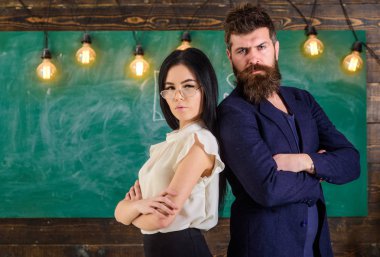 Sakal ve gözlük stand sırt sırta, kara tahta arka plan öğretmen olan adam. Öğretmen ve öğretmen rahat görünüyor. Bayan ve birlikte okulda çalışan hippi. Okul personeli kavramı