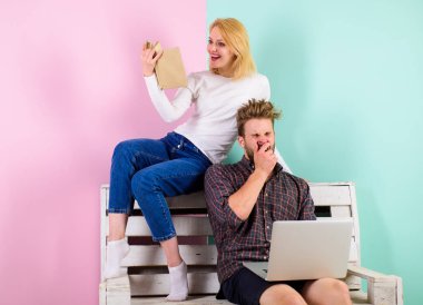 İlgi odağı. Kız ve adam entelektüel faaliyet baktılar. Dizüstü bilgisayar ve kitap hevesli entelektüel faaliyet kadınla olan adam. Çift farklı ilgi alanları ile birlikte vakit