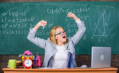 Vivacity korumak için egzersizler. Öğretmen kadın tablo sınıf kara tahta arka plan otur. Çok gerçek okul gün çalışıyorum. Vivacity artırmak ve enerji ücret almak için egzersizleri yapın ve streç