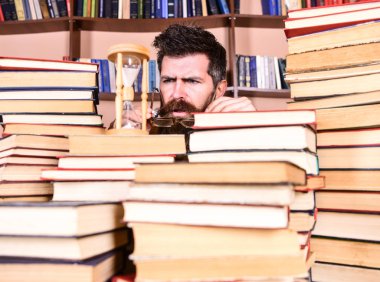 Zaman akışı kavramı. Dostum, bilim adamı bardaklarda kum saati görünüyor. Öğretmen ya da sakal Kitaplığı'nda eğitim ile öğrenci. Adam ciddi yüz izlerken zaman raflardan, arka planda gidiyor