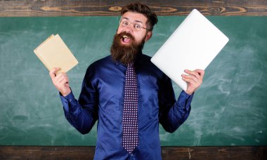 Modern teknoloji ile kal. Öğretmen sakallı hippi kitap ve laptop tutar. Modern teknolojiler yarar. Öğretmen modern öğretim yaklaşımı seçme. Dijital kağıt karşı. Şu öğretim yöntemi seçin