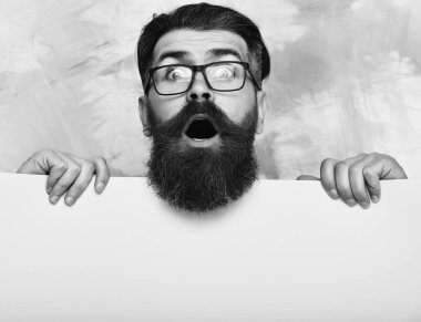 Renkli arka planda gözlüklü, şaşkın suratlı sakallı bir adam.