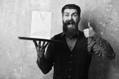 Garson tepsi üzerinde beyaz paketi ile. Hizmet ve satınalma kavramı. İşadamı heyecanlı yüz