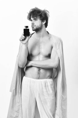 Beyaz arka plan üzerinde izole parfüm kullanan yakışıklı genç adam.