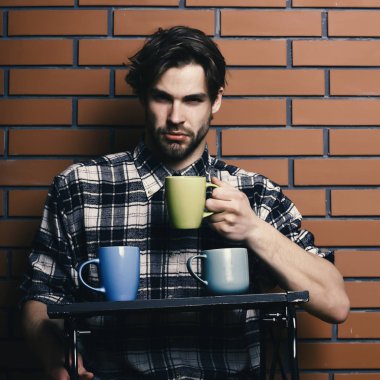bardak dokulu tuğla duvar ahşap tepsi tutarak siyah arka plan, kopya alanı, yakışıklı adam tuğla duvar arka plan üzerinde bardak