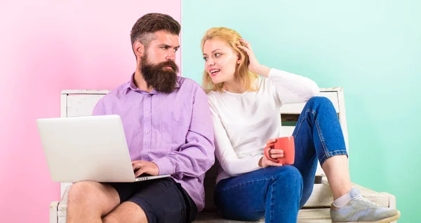 Freelance benefits. Man works as internet technologies expert on freelance. Woman smiling face drink tea or coffee near man working. Girl enjoy drink while husband freelancer works with laptop