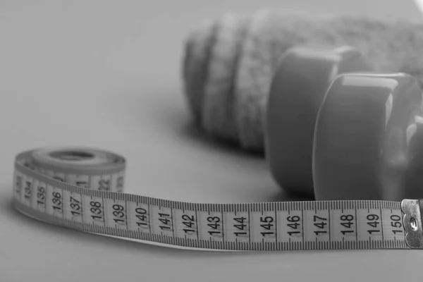 Dumbbells in green color, twisted measure tape and towel — Stock Photo, Image