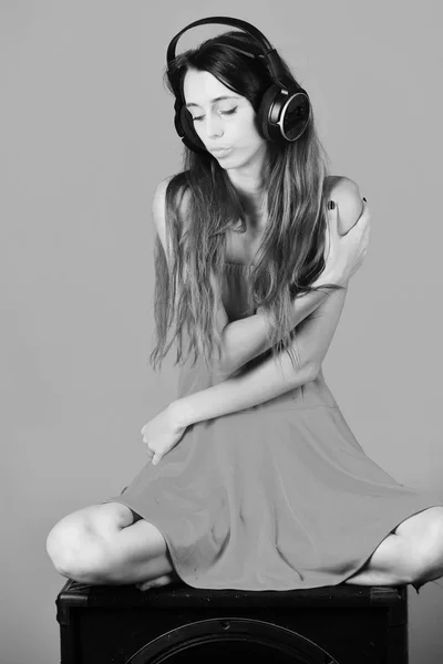 音楽、パーティ、レジャーの概念。緩い毛を持つ少女はヘッドフォンと赤いドレスを着ています。. — ストック写真