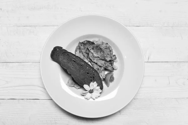 Cena servida en plato tradicional. Filetes de carne, ensalada y tostadas decoradas con manzanilla . — Foto de Stock