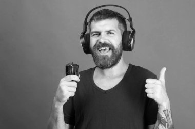 Şarkıcı sakal ve güler yüz ile müzik dinliyor. Zevk, müzik ve yaratıcı yaşam tarzı kavramı. DJ sakallı