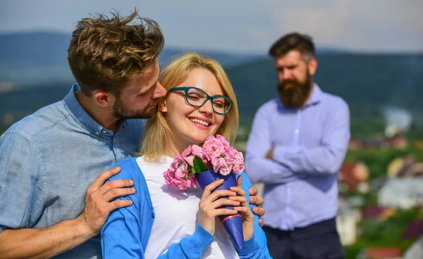 Couple amoureux sortir ensemble tandis que l "homme barbu jaloux regarder femme le tromper avec amant. Amoureux câlins flirt en plein air relations romantiques. Concept d'infidélité. Couple romantique amoureux date bouquet fleurs — Photo