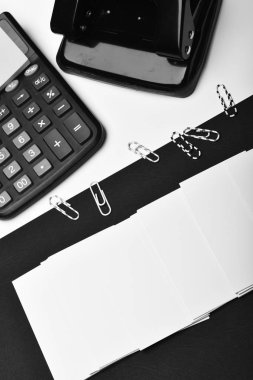 Hesap makinesi, not kağıdı, ataç ve delik açma. İş ve iş kavramı: siyah ve beyaz olarak ileti örneği