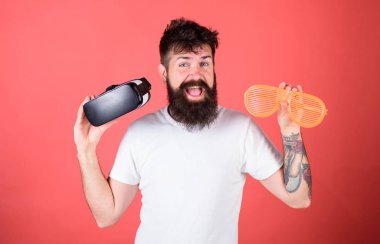 Sanal gerçeklik kulaklık ve kırmızı zemin üzerine çok güneş gözlüğü sakallı adam hippi. Adam ne tercih gerçek veya sanal karar. Gerçeklik ve Vr. alternatif gerçeklik arasında seçim