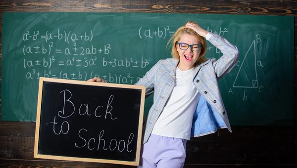 Offre spéciale retour à l'école. Une enseignante tient un tableau noir à l'inscription de l'école sur fond de tableau. Postulez pour une offre éducative sensationnelle. Offre spéciale vente discount saison scolaire — Photo