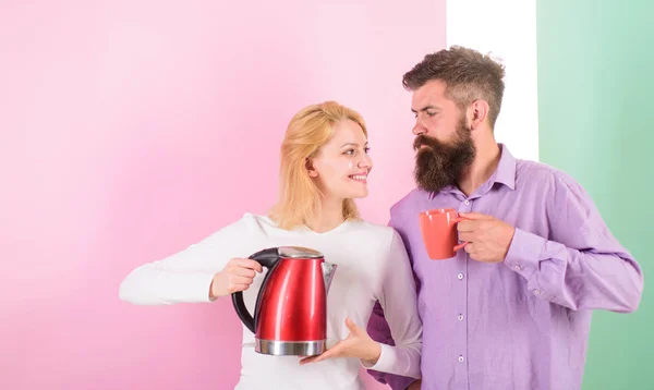Spending good morning together. Couple prepare morning drink electric kettle device. Electric kettle boils water very quickly. Prepare favourite drink in minutes. Modern devices make our life easier